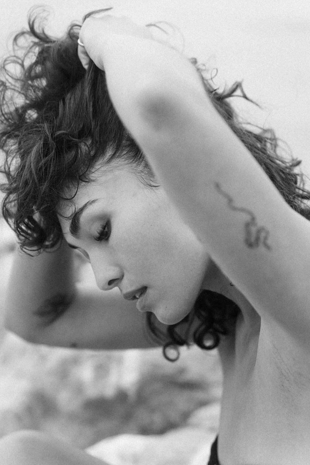 Black and white close frame, arms raised overhead, tattoo visible — SYDNEY, by Kenneth Kemp